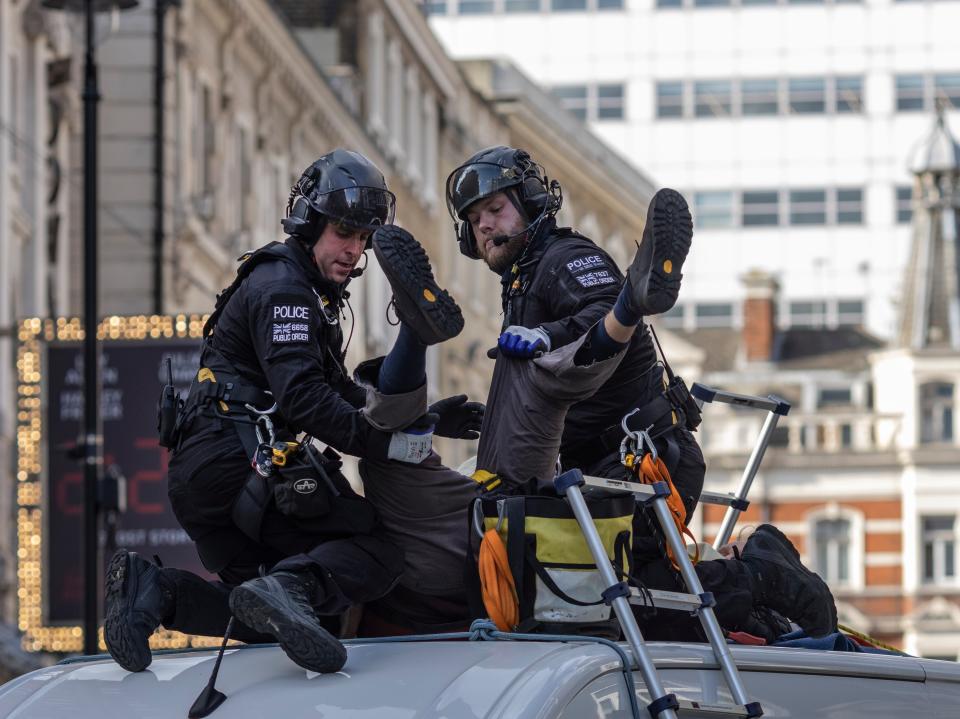 An XR protester, who installed himself on top of a van near Covent Garden, is arrested by police (Getty)