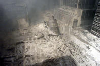 Un grupo de bomberos camina entre los escombros en la base de la torre sur del World Trade Center.<br><br>Foto: REUTERS/Peter Morgan