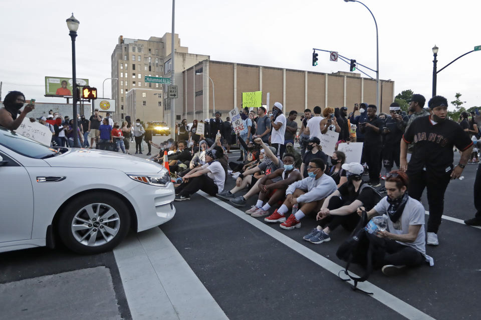 Protesters sit at an intersection during a protest over the deaths of George Floyd and Breonna Taylor, Saturday, May 30, 2020, in Louisville, Ky. Breonna Taylor, a black woman, was fatally shot by police in her home in March. (AP Photo/Darron Cummings)