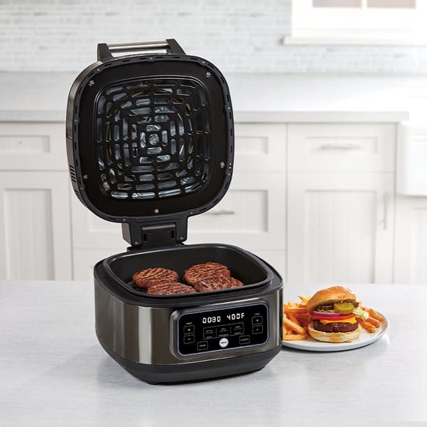 Black grill pan with burger patties inside