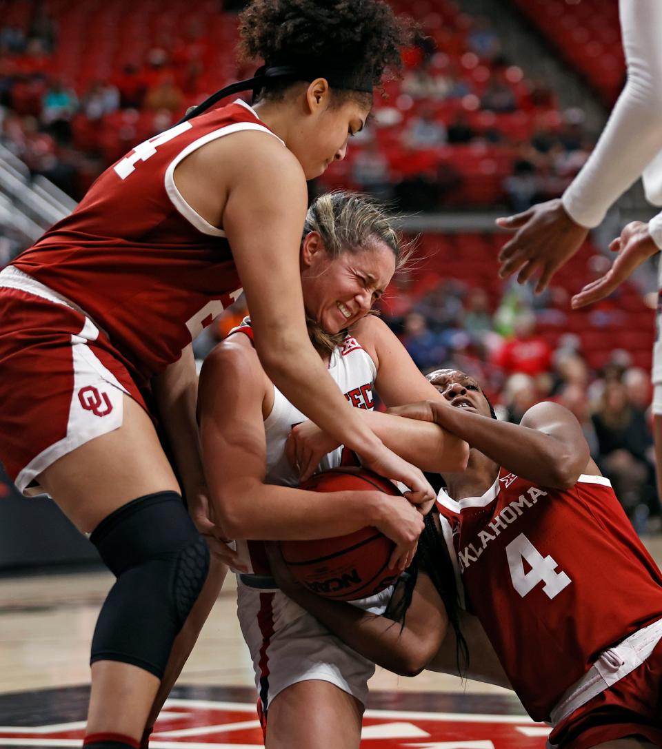 Texas Tech's Lexy Hightower (4), Oklahoma's Skylar Vann (24) and Kennady Tucker (4) grab the ball during the second half of an NCAA college basketball game on Sunday, Jan. 2, 2022, in Lubbock, Texas.