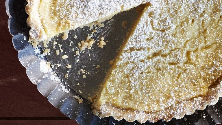 lemon buttermilk tart in a metal pie tin with powdered sugar on top