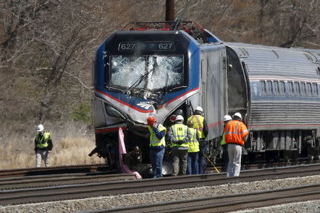 Emergency personnel examine the scene after an Amtrak passenger train struck a backhoe, killing two people, in Chester, Pennsylvania, April 3, 2016. REUTERS/Dominick Reuter