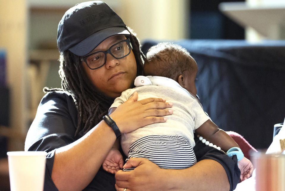 Georgia State Sen. Kim Jackson holds her son as she takes part in a reproductive health town hall meeting at Neighborhood Church Thursday, Aug. 29, 2024, in Atlanta. (AP Photo/John Bazemore)