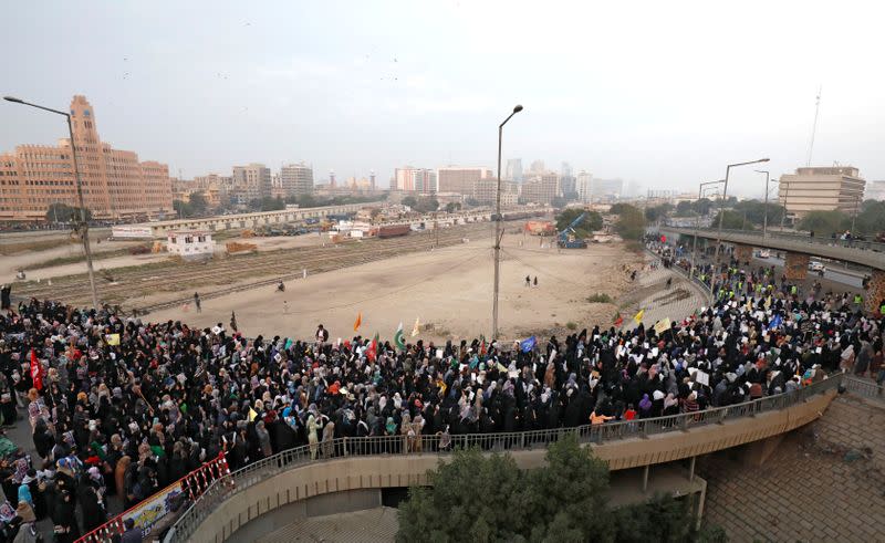 Pakistani Shi'ite Muslims carry flags and signs to protest the death of Iranian military commander Qassem Soleimani, who was killed in a airstrike near Baghdad, as they march on a road leading towards the U.S. consulate in Karachi