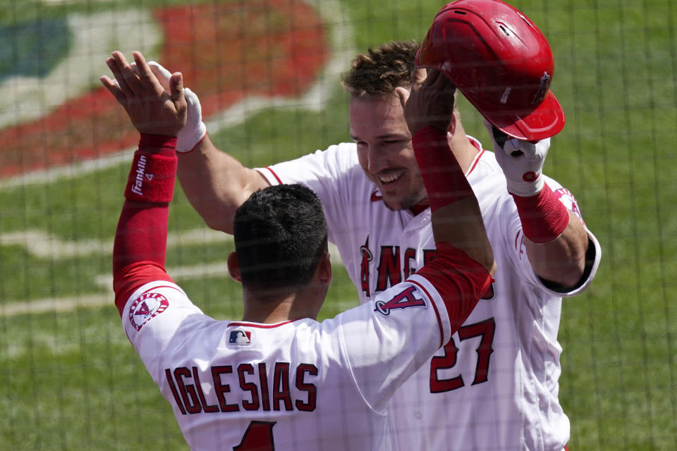 Los Angeles Angels' Mike Trout, right, is congratulated by Jose Iglesias after hitting a two-run home run during the first inning of a baseball game against the Houston Astros Tuesday, April 6, 2021, in Anaheim, Calif. (AP Photo/Mark J. Terrill)