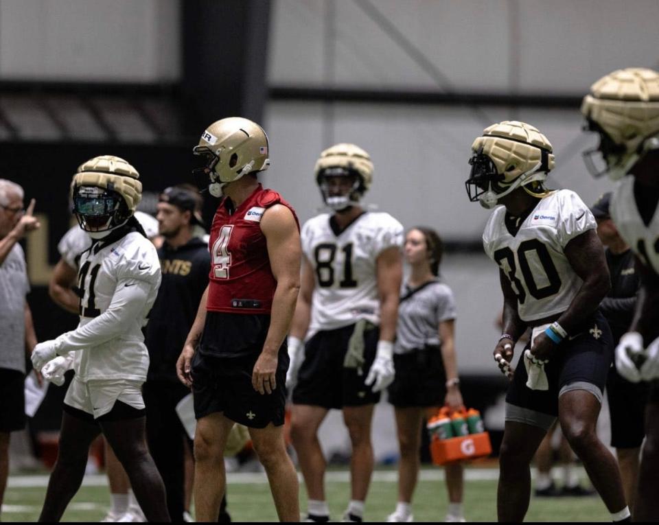 Noel Kruse (background) is shown holding Gatorade bottles during a practice inside the Saints' practice facility during her preseason athletic training internship.