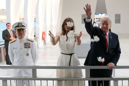 U.S. President Donald Trump and first lady Melania Trump scatter flower petals in the water at the USS Arizona Memorial in Honolulu, Hawaii, U.S. November 3, 2017. REUTERS/Jonathan Ernst