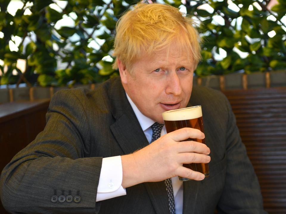 Boris Johnson sips a pint on the local election campaign trail (PA)