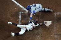 Los Angeles Dodgers catcher Will Smith can not make the tag on Atlanta Braves Ozzie Albies scores on a single by Austin Riley in the eighth inning in Game 2 of baseball's National League Championship Series Sunday, Oct. 17, 2021, in Atlanta. (AP Photo/John Bazemore)
