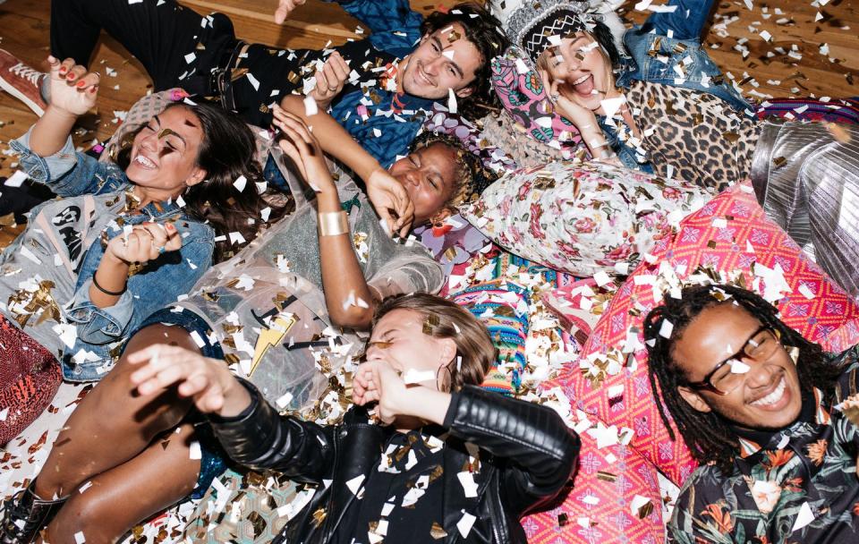 group of friends having fun with confetti on the floor
