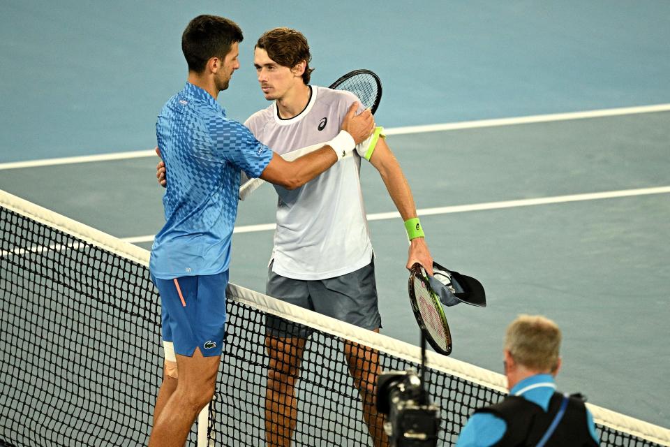 Serbia's Novak Djokovic (L) embraces Australia's Alex De Minaur after their men's singles match on day eight of the Australian Open tennis tournament in Melbourne on January 23, 2023. - -- IMAGE RESTRICTED TO EDITORIAL USE - STRICTLY NO COMMERCIAL USE -- (Photo by ANTHONY WALLACE / AFP) / -- IMAGE RESTRICTED TO EDITORIAL USE - STRICTLY NO COMMERCIAL USE -- (Photo by ANTHONY WALLACE/AFP via Getty Images)