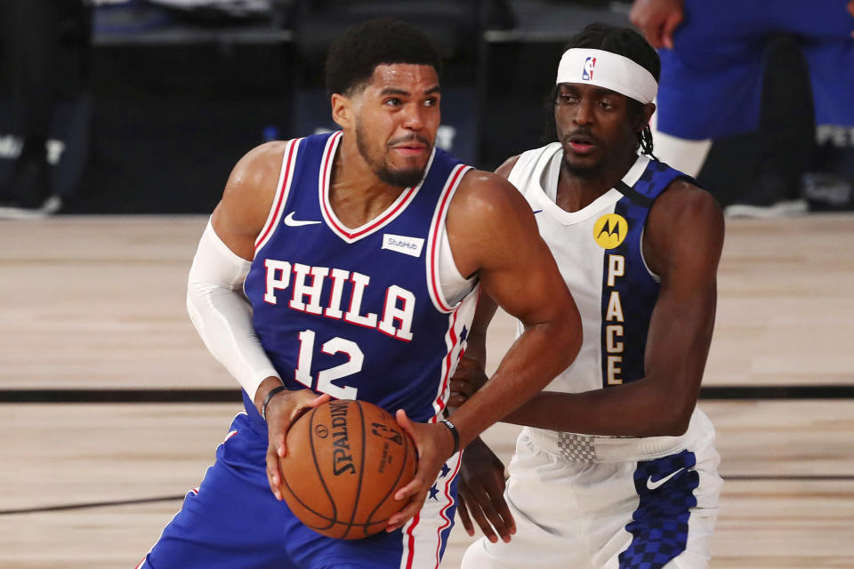 Philadelphia 76ers forward Tobias Harris (12) drives to the basket against against Indiana Pacers forward Justin Holiday (8) during the fourth quarter of an NBA basketball game Saturday, Aug. 1, 2020, in Lake Buena Vista, Fla. (Kim Klement/Pool Photo via AP)