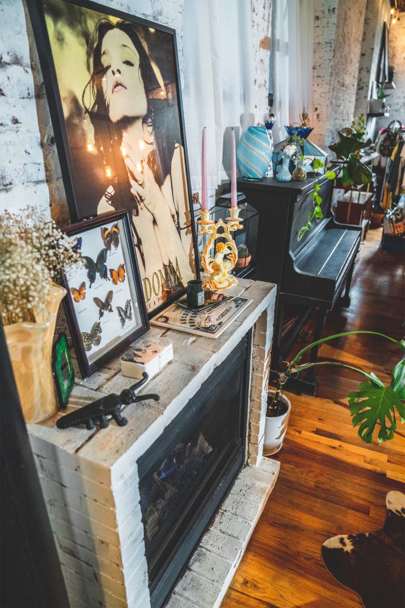 Art and candles on top of apartment fireplace.