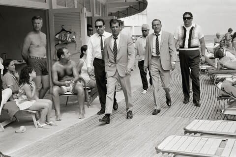 Frank Sinatra, with his minders and his stand in (who is wearing an identical outfirt to him), arriving at Miami beach while filming, 'The Lady in Cement.' Photograph taken by Terry O'Neill CBE in 1968 - Credit: Terry O'Neill / Iconic Images