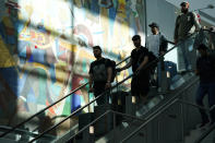 Travelers ride an escalator to the concourse at Miami International Airport ahead of the Thanksgiving holiday, Wednesday, Nov. 22, 2023, in Miami. (AP Photo/Lynne Sladky)