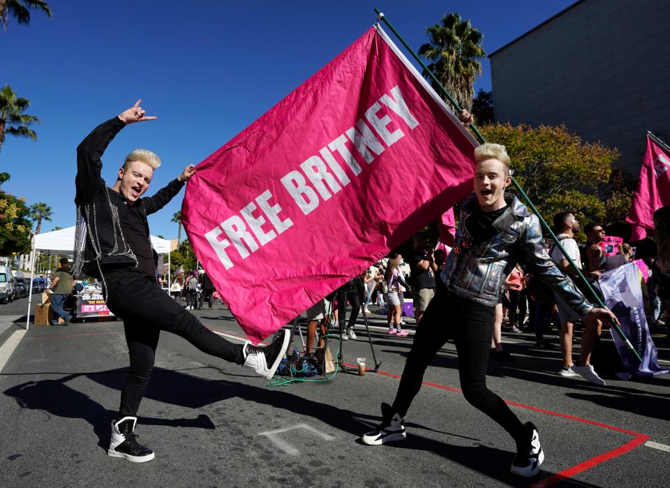 Twins Edward, right, and John Grimes of Dublin, Ireland, hold a "Free Britney" flag outside a hearing concerning the pop singer's conservatorship on Friday, Nov. 12, 2021.