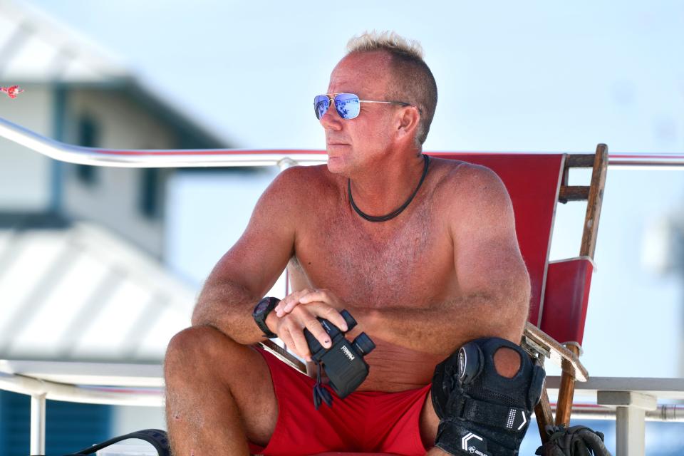 Lifeguard Ross Carter with Walton County Beach Safety keeps an eye on swimmers Monday at the Miramar Beach Regional Access on Scenic Gulf Drive.  There have been fewer public assist calls than last year and no swimmer fatalities thus far.