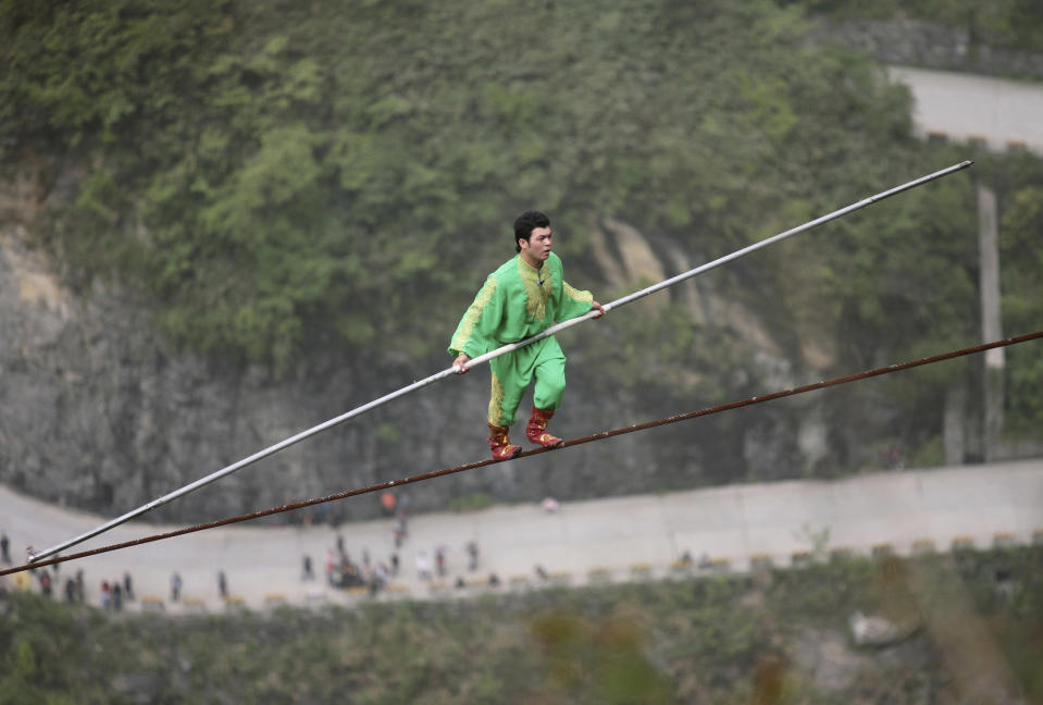 Samat Hasan, a 24-year-old stuntman from the Xinjiang Uighur Autonomous Region, walks on a tightrope in Zhangjiajie, Hunan province April 25, 2009. Walking on a 700-metre-long (2,300 ft) rope with a 3.1-centimetre (1.2 inches) diameter and set at a 39-degree gradient, Hasan successfully broke the Guinness World Record for aerial tightrope walking after failing in a previous attempt in October last year, local media reported. REUTERS/China Daily