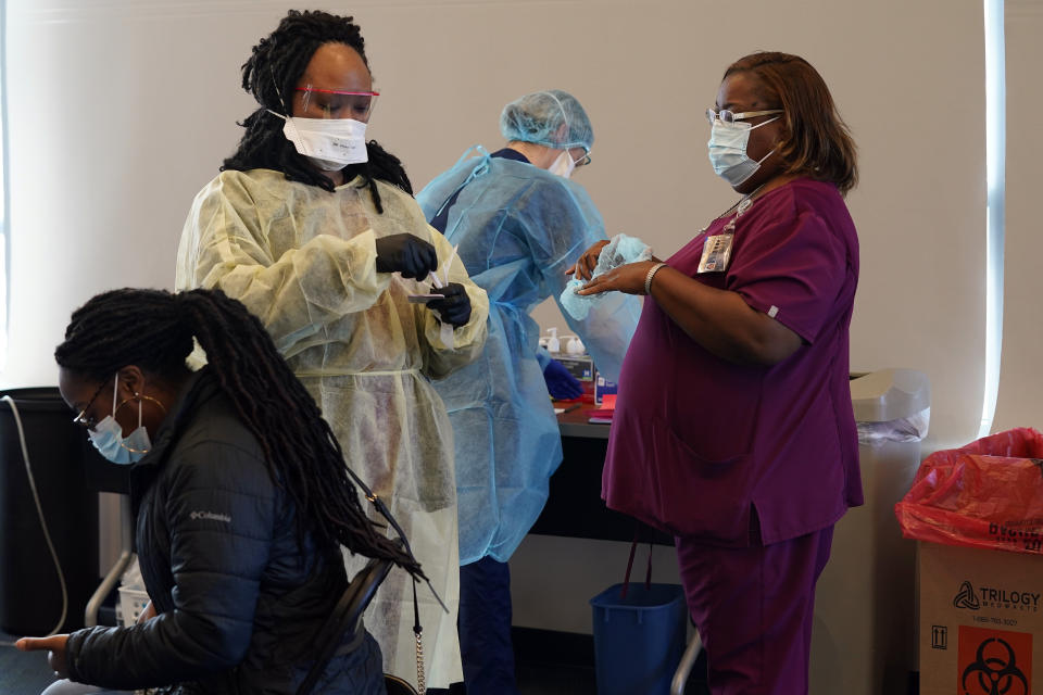 A student, seated left, waits for a coronavirus test at the student health center on campus at North Carolina Agricultural and Technical State University in Greensboro, N.C., Wednesday, Feb. 3, 2021. As vaccinations slowly ramp up, some experts say turning to millions more rapid tests that are cheaper but technically less accurate may improve the chances of identifying sick people during the critical early days of infection, when they are most contagious. (AP Photo/Gerry Broome)