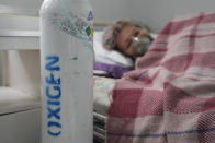 A patient breathes through an oxygen mask at the COVID-19 unit of the Marius Nasta National Pneumology Institute in Bucharest, Romania, Thursday, Sept. 23, 2021. Daily new coronavirus infections in Romania, a country of 19 million, have grown exponentially over the last month, while vaccine uptake has declined to worrying lows. Government data shows that 91.5% of COVID-19 deaths in Romania between Sept. 18-23 were people who had not been vaccinated. (AP Photo/Vadim Ghirda)