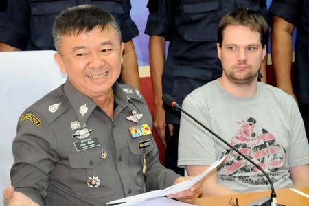 Hans Fredrik Lennart Neij (R), a co-founder of the Swedish file-sharing website, The Pirate Bay, is surrounded by police officers at the immigration office in Nong Khai province November 4, 2014. REUTERS/ Daily News