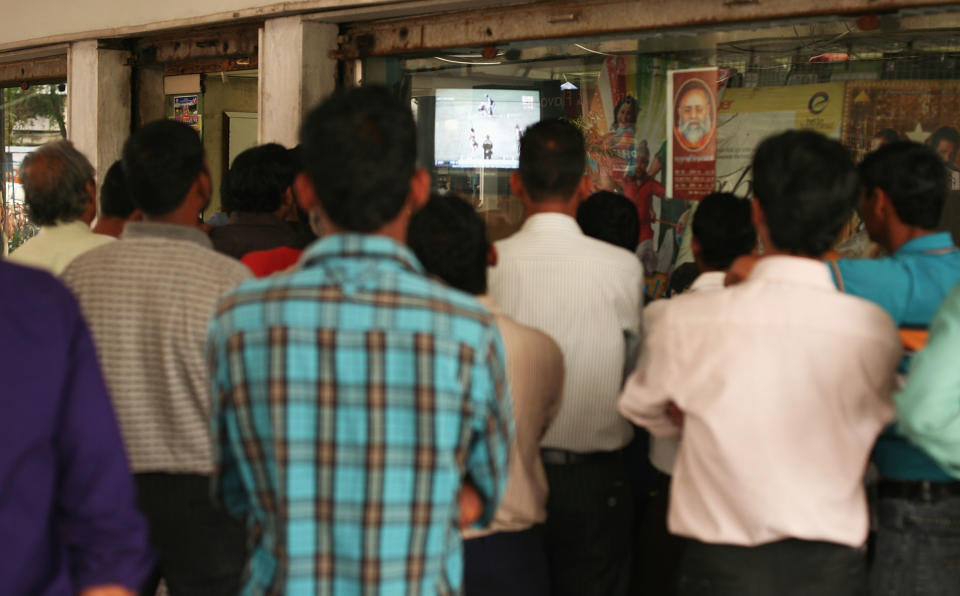 CHANDIGARH, INDIA - MARCH 25:  Local men gather around a shop window to watch the television coverage of the Indian Premier League cricket in sector 22 market place on March 25, 2010 in Chandigarh, India.  (Photo by Mark Kolbe/Getty Images)