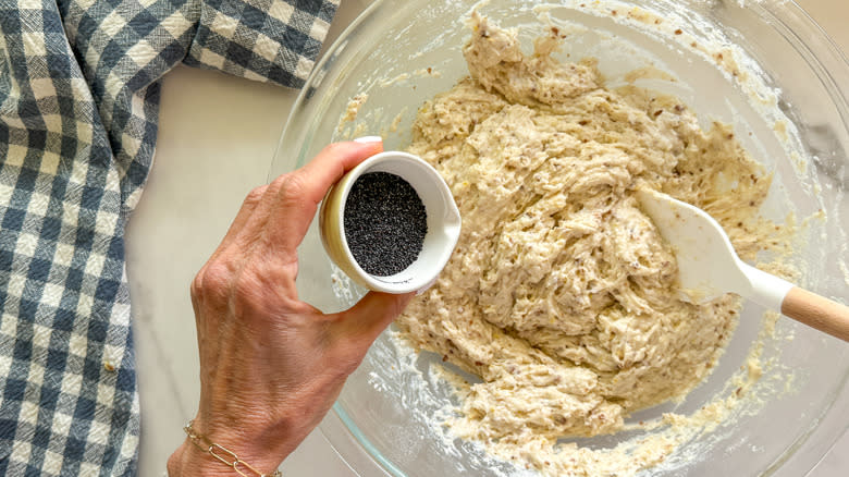 hand mixing lemon poppy seed muffin batter in bowl