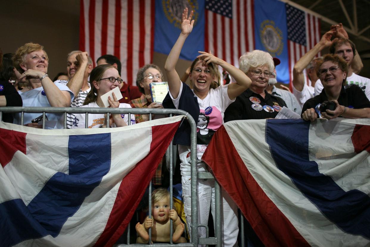 A baby looks through a barricade as supporters cheer during a rally for democratic presidential hopeful U.S. Sen. Hillary Clinton (D-NY) at the W.H. Lyon Fairgrounds June 2, 2008 in Sioux Falls, South Dakota.