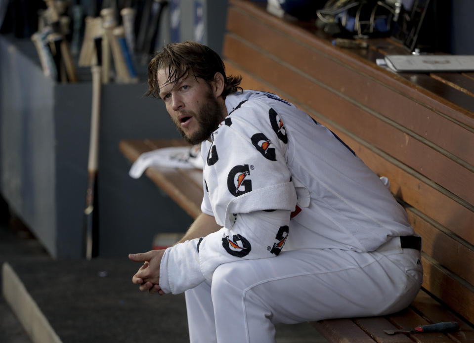 Clayton Kershaw, abridor de los Dodgers de Los Ángeles, se sienta en el dugout durante el quinto juego de la Serie Mundial ante los Medias Rojas de Boston, el domingo 28 de octubre de 2018 (AP Foto/Jae C. Hong)