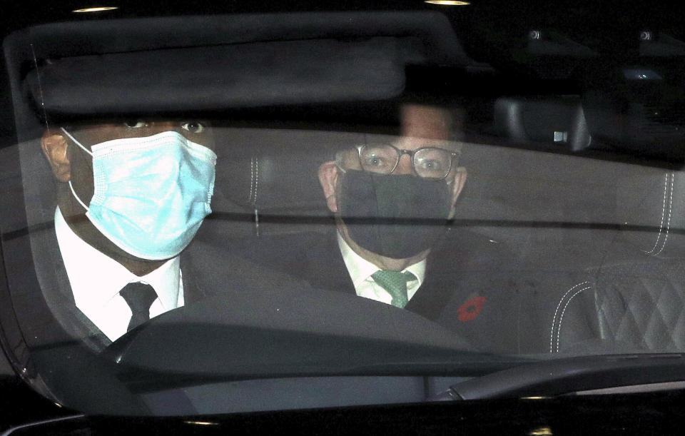 British lawmaker Michael Gove, right, is driven away following his appearance on a current affairs TV programme in London, Sunday Nov. 1, 2020. The British government announced on Saturday a four-week public lockdown in response to the coronavirus, but Michael Gove on Sunday acknowledged that the lockdown could be extended. (Jonathan Brady/PA via AP)