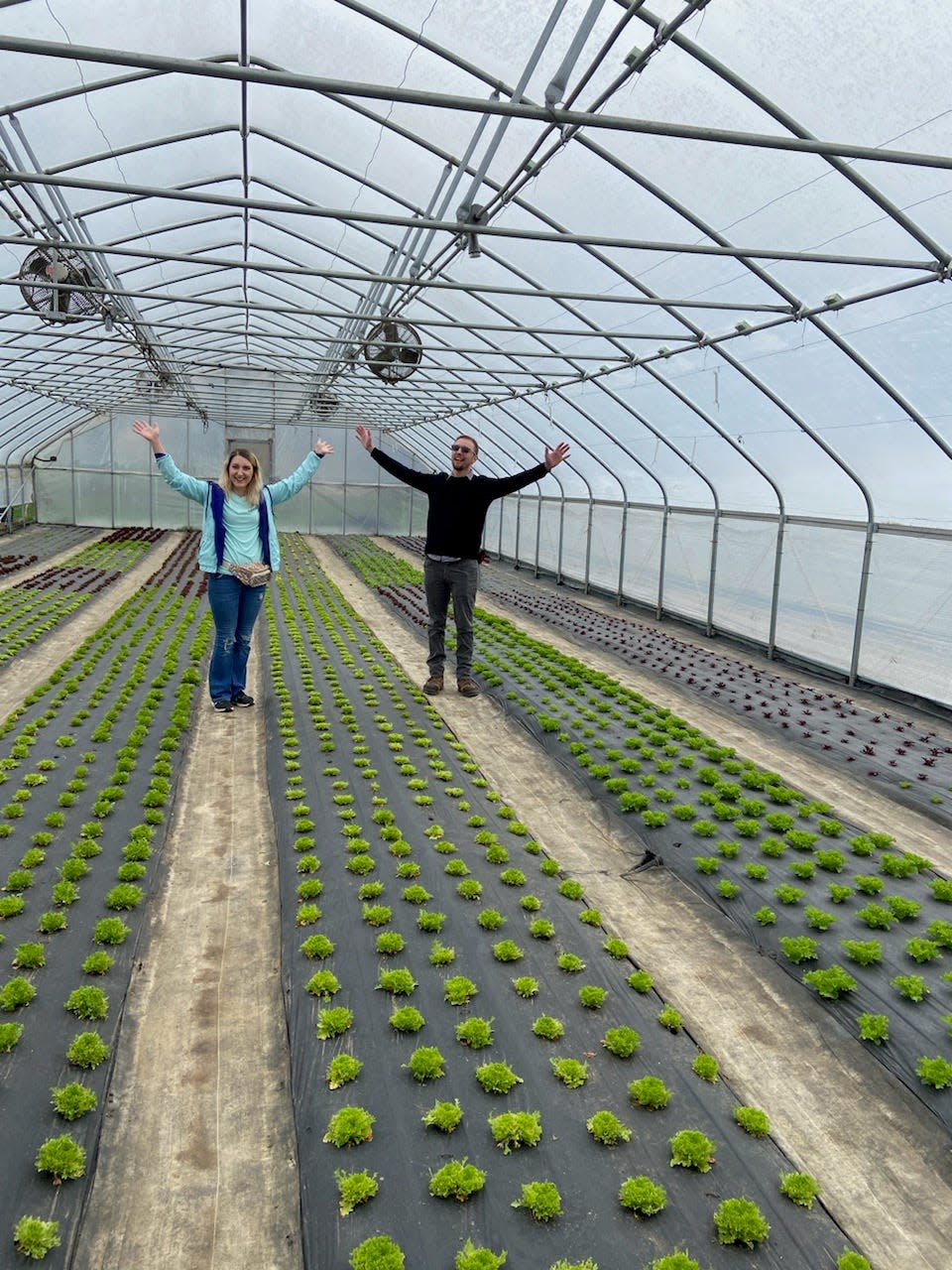 At the Crawford County Farm Hop stop at Edible Landscapes, Samantha and Jake Rittenour gesture with raised arms to celebrate making it through their first winter.