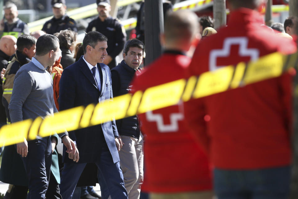Spanish Prime Minister Pedro Sanchez arrives at the site of the fourteen-story building burned down in Valencia, Spain, Friday, Feb. 23, 2024. Firefighters continue cooling the skeleton of two residential buildings where they want to search for nearly 20 people missing after a fire intensified by strong winds spread quickly on Thursday night. 4 people died and 14 were injured. (AP Photo/Alberto Saiz)