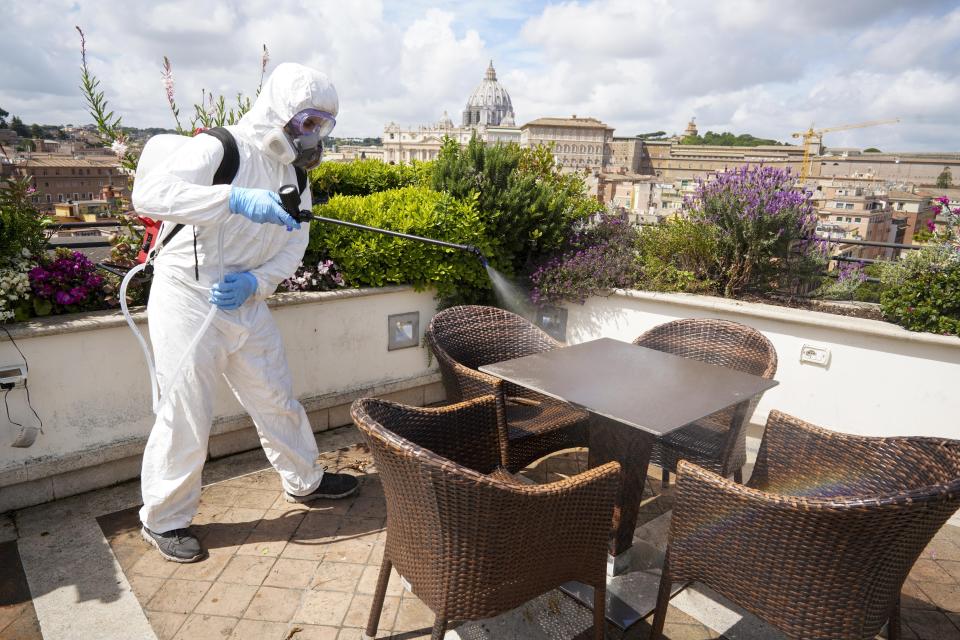 A worker disinfects the roof terrace of the Atlantic hotel, in Rome, Wednesday, April 29, 2020. After seven weeks in lockdown to contain one of the world’s worst outbreaks of COVID-19, Italians are regaining some freedoms, starting on May 4, public parks and gardens will re-open and people will be able to visit relatives who live in the same region. (AP Photo/Andrew Medichini)