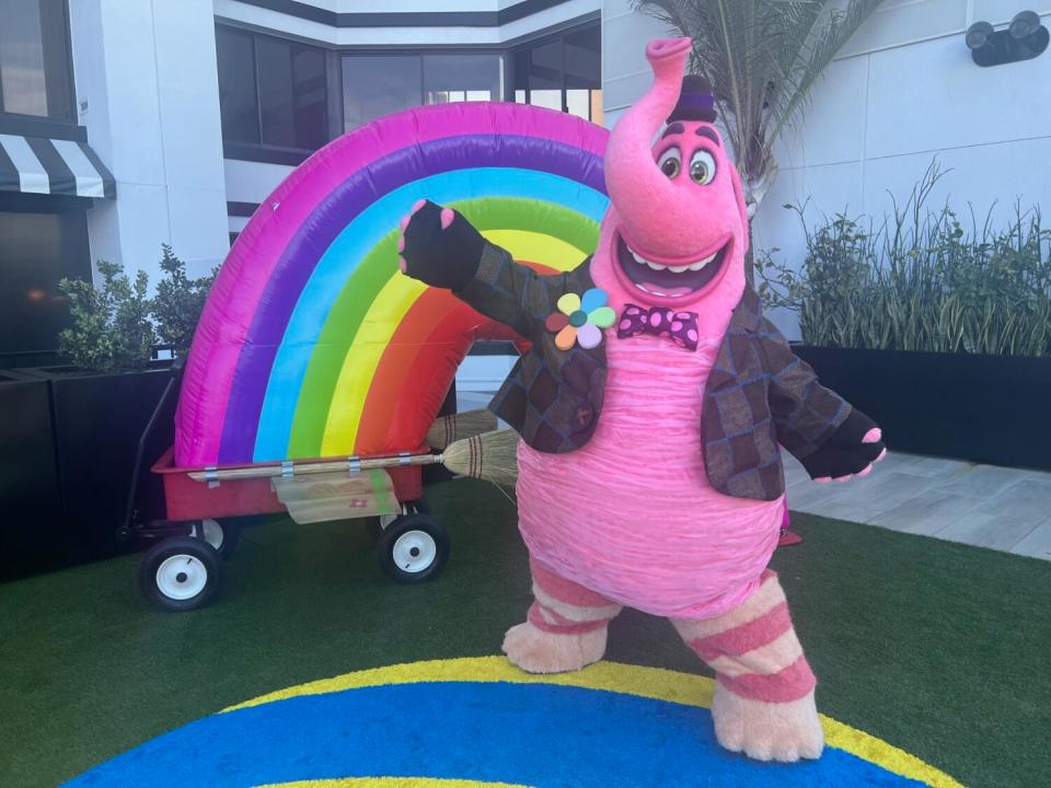 A pink elephant-like creature greets guests.