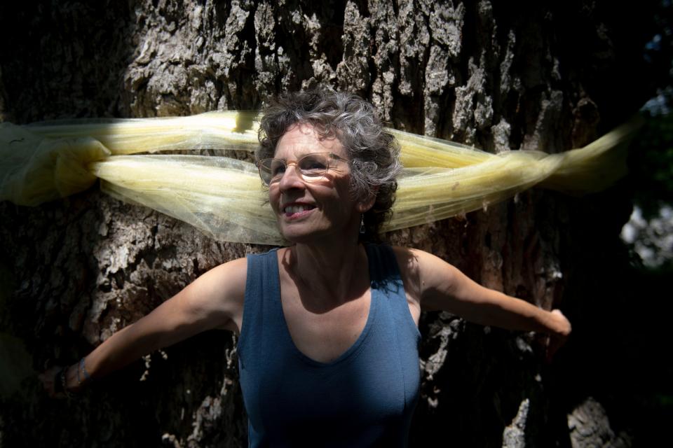 Ruth Osburn stands near the 340-year-old tree she helped save in Williamson County. The tree's wrinkled trunk measures 227 inches in circumference and 67 inches in diameter.