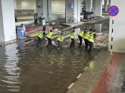 A crew removes water outside the Indira Gandhi International Airport after a heavy downpour in New Delhi, India, Friday, June 28, 2024. A portion of the canopy at a departure terminal of the airport collapsed early Friday as heavy pre-monsoon rains lashed the Indian capital. (AP Photo/Shonal Ganguly)