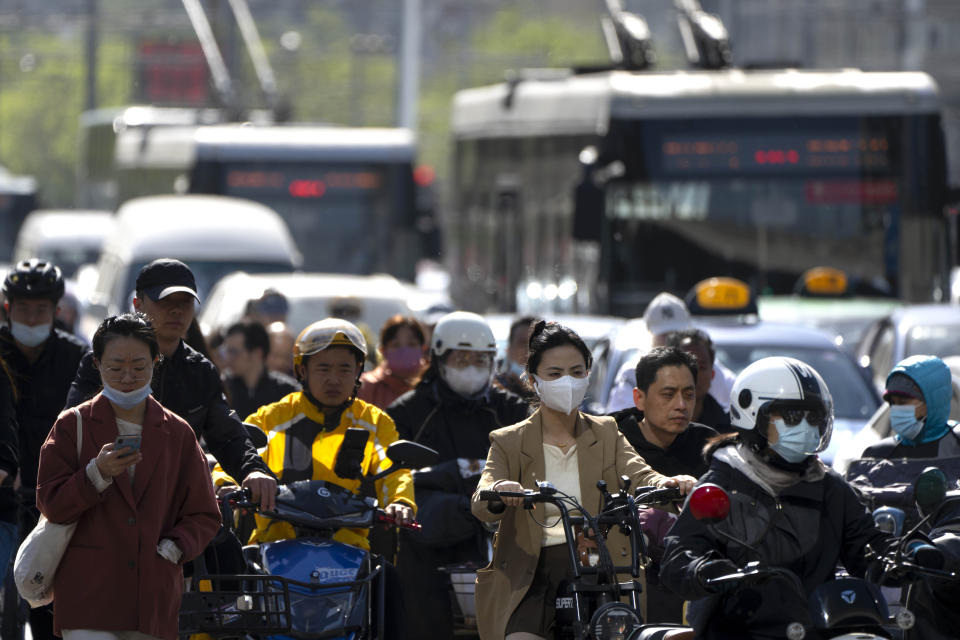 Commuters cross an intersection in the central business district during the morning rush hour in Beijing, Tuesday, April 18, 2023. China’s economy grew 4.5% in the first quarter of the year, boosted by increased consumption and retail sales, after authorities abruptly abandoned the stringent "zero-COVID" strategy. (AP Photo/Mark Schiefelbein)