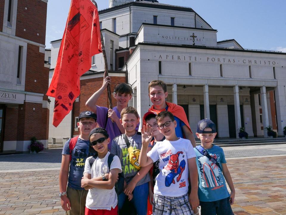 Noah Bock (back row, wearing orange) is shown with his group of Ukrainian boys. Bock volunteered at an English immersion camp, held at the Saint John Paul II Polish Center in Krakow, Poland. The center is in the background.