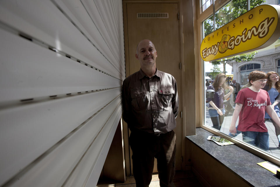 Owner Marc Josemans poses for a portrait next to the closed shutters inside his coffeeshop Easy Going in Maastricht, southern Netherlands, Tuesday May 1, 2012. A policy barring foreign tourists from buying marijuana in the Netherlands goes into effect in parts of the country Tuesday, with a protest planned in the southern city of Maastricht. Josemans first refused foreigners entry Tuesday to provoke a complaint for discrimination, to later sell marijuana to foreigners to provoke a police reaction. Later it closed its doors as all other coffeeshops in Maastricht were closed. (AP Photo/Peter Dejong)