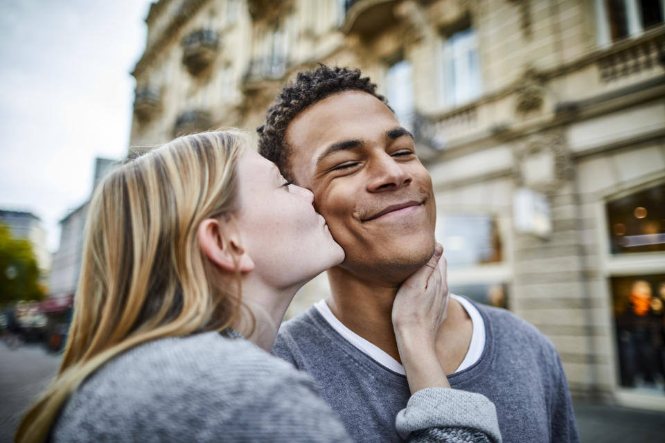 Young woman kissing boyfriend in the city