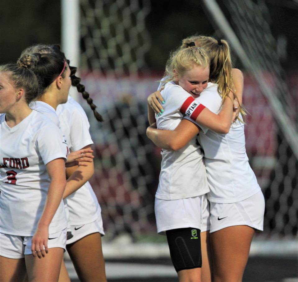 Milford senior Ana Manning (with captain's armband) hugs a teammate after Manning scored to give the Eagles a 1-0 lead during Anderson's 2-2 draw with Milford in a battle for first place in girls soccer in the Eastern Cincinnati Conference Sept. 21, 2023 at Anderson's Brown Stadium.