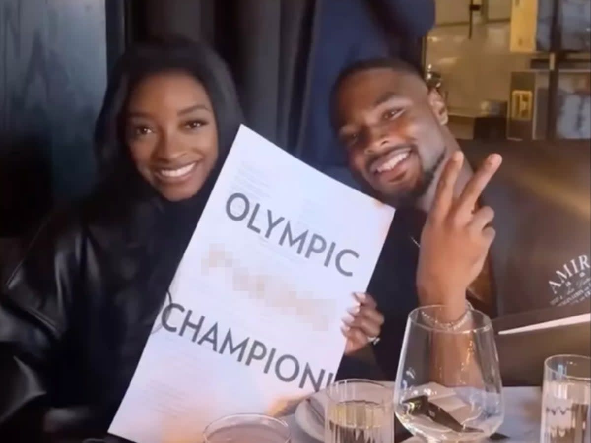 Simone Biles poses with husband at restaurant with menus reading ‘Olympic F***ing Champion’ (Instagram)