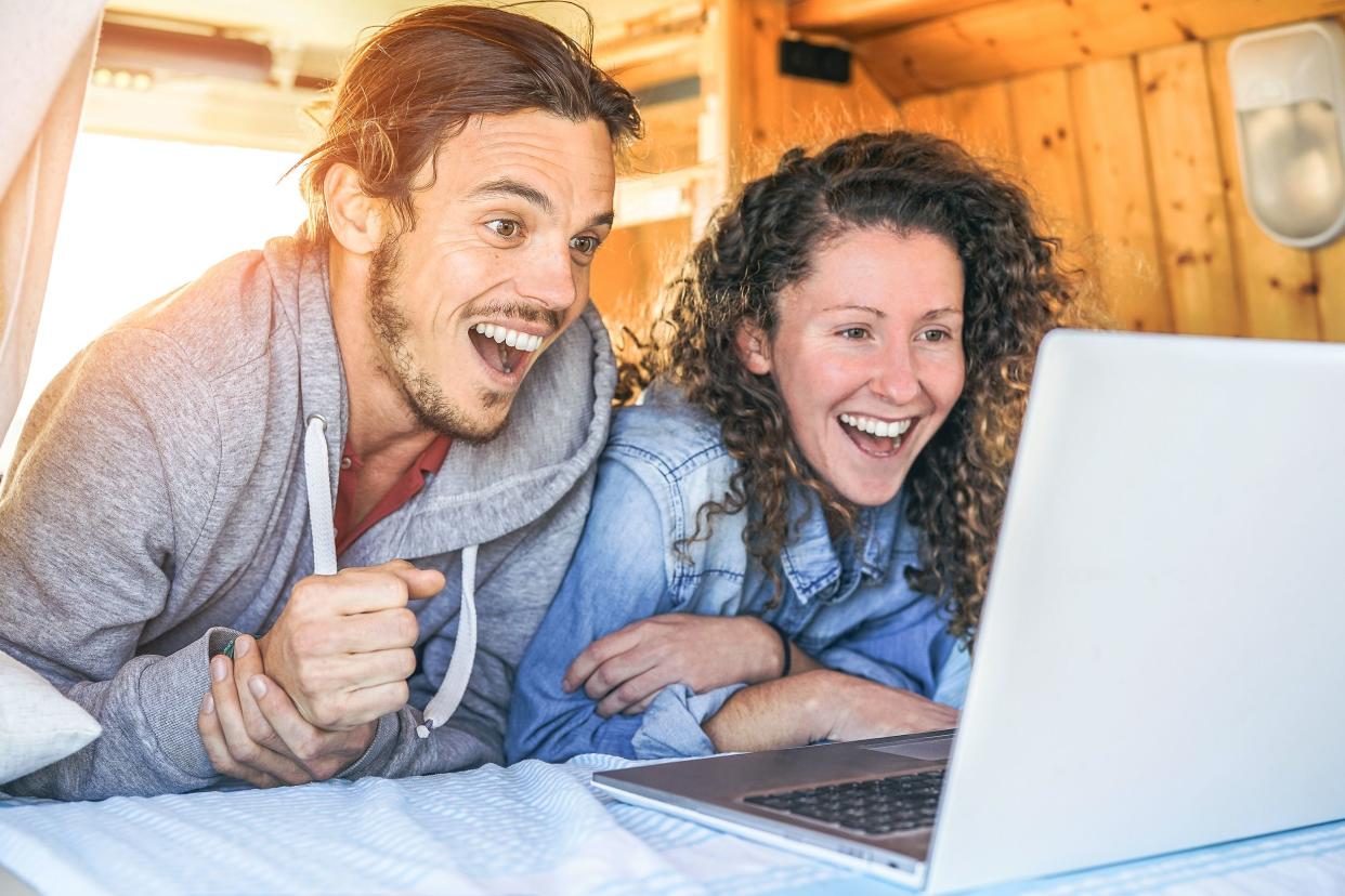 happy couple using laptop in motor home