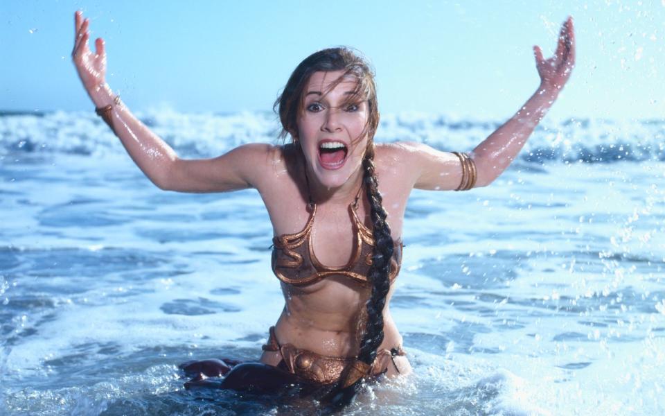 Was sich alle "Star Wars"-Fans immer fragten: Kann man in Prinzessin Leias bronzenem Bikini baden? Man kann, wie Carrie 1983 in einem Fotoshooting für den "Rolling Stone" zeigte. (Bild: Aaron Rapoport/Corbis via Getty Images)