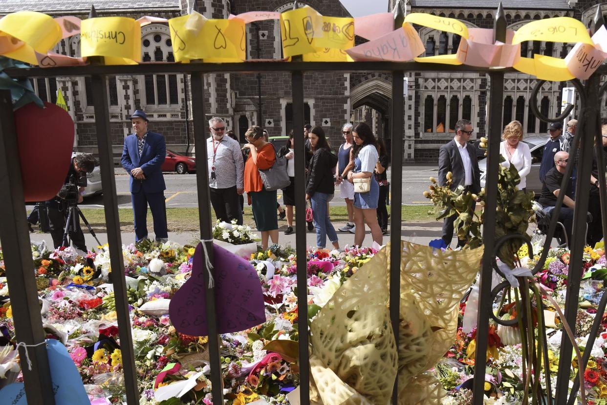 People look at tributes at the Botanic Gardens in Christchurch on March 21, 2019, six days after the twin mosque shooting massacre that claimed the lives of fifty people. - New Zealand is banning the sale of assault rifles and semi-automatic weapons with almost immediate effect, Prime Minister Jacinda Ardern said on March 21, rapidly making good on a pledge to tighten the country's gun laws. (Photo by WILLIAM WEST / AFP)        (Photo credit should read WILLIAM WEST/AFP/Getty Images)