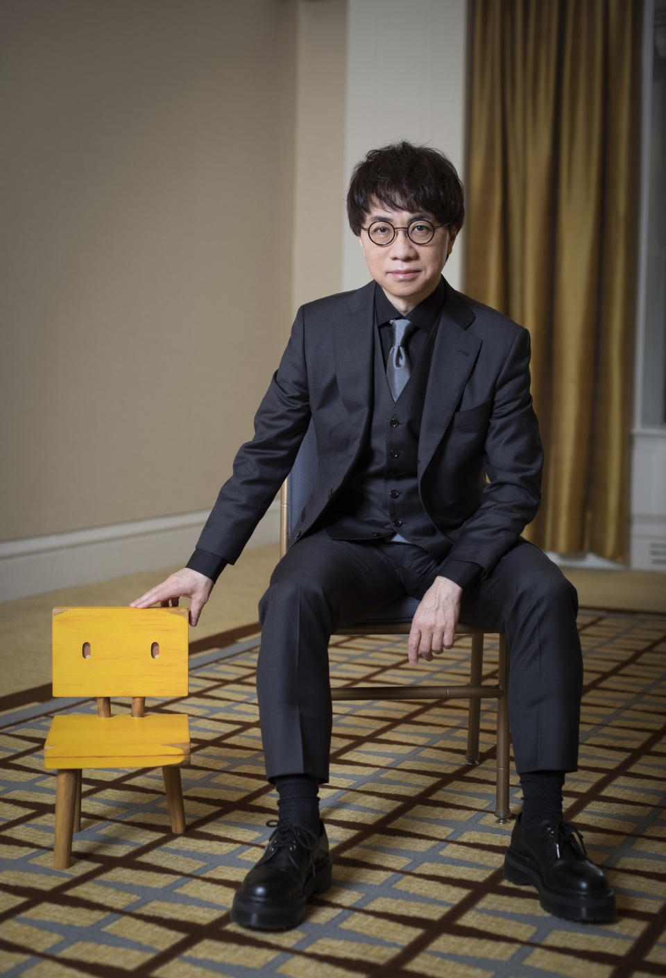 Makoto Shinkai poses for a portrait to promote the film "Suzume" on Tuesday, March 28, 2023 in New York. Shinkai was never the same filmmaker after the 2011 earthquake stuck Japan. His top three films since – "Your Name," "Weathering With You" and the new release "Suzume" -- have each tethered hugely emotional tales to ecological disaster. And they account for some of the biggest anime hits of all time. "Suzume" has already grossed more than $200 million. (Photo by Matt Licari/Invision/AP)