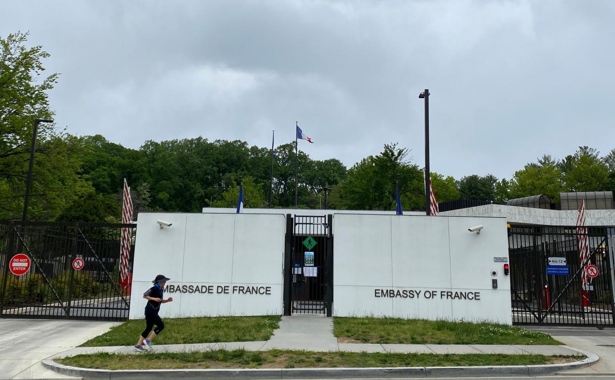 A woman runs in front of the closed French Embassy in Washington, D.C.
