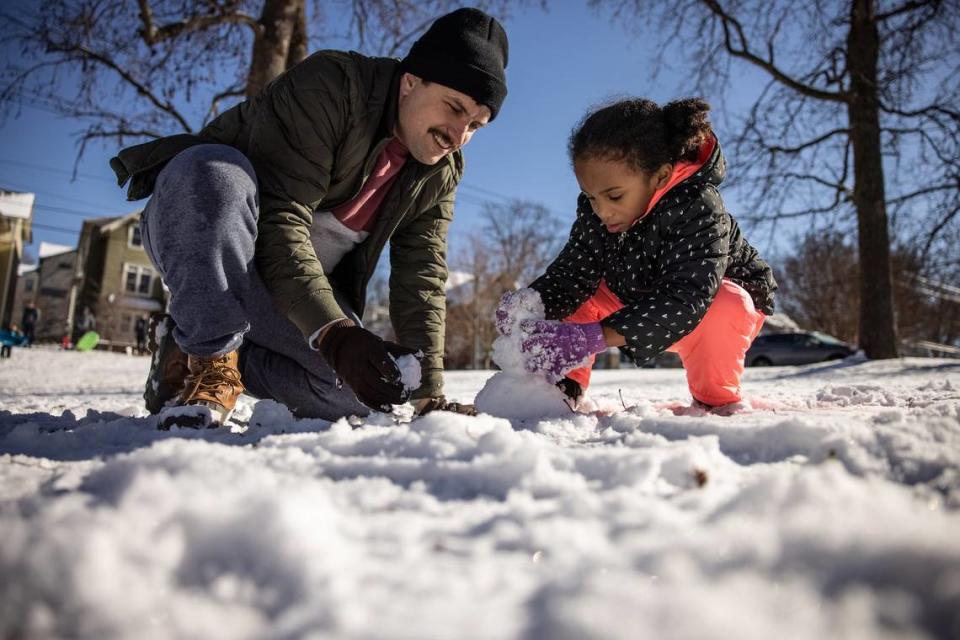 Doug Meardon, left, makes a snowman with Ava Norman, 4, in Charlotte, N.C., on Saturday, January 22, 2022. Charlotte broke a 39-year-old record when 1.9 inches of snow fell during Friday night’s storm, the National Weather Service reported Saturday.