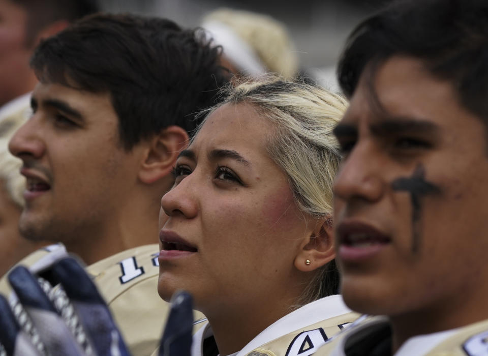 Pumas' kicker Andrea Martinez sings her team's anthem before a Liga Mayor football match against Aztecas in Mexico City, Saturday, Oct. 8, 2022. Martinez stopped playing soccer to become the first woman to play college football amongst men in Mexico's top amateur division. (AP Photo/Fernando Llano)